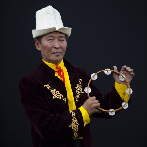 Man Wearing Traditonal Clothes And Kalpak Hat Playing Tambourine,  Saralasaz Jailoo, Kyrgyzstan