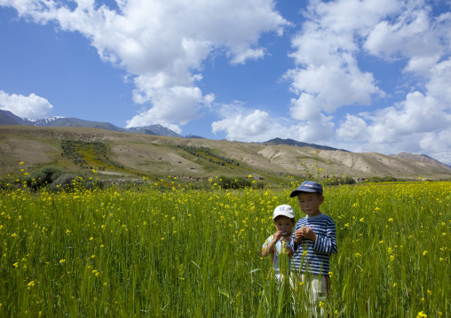 Two Young Boys With Caps In The Fields, Road To Jaman Echki Jailoo, Kyrgyzstan