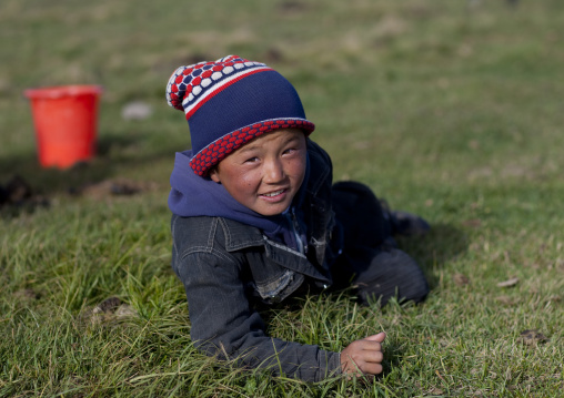 Boy Laying Down In The Grass, Jaman Echki Jailoo Village, Song Kol Lake Area, Kyrgyzstan