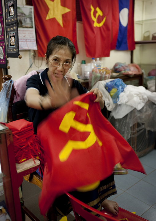 Woman sewing communist flags, Pakse, Laos