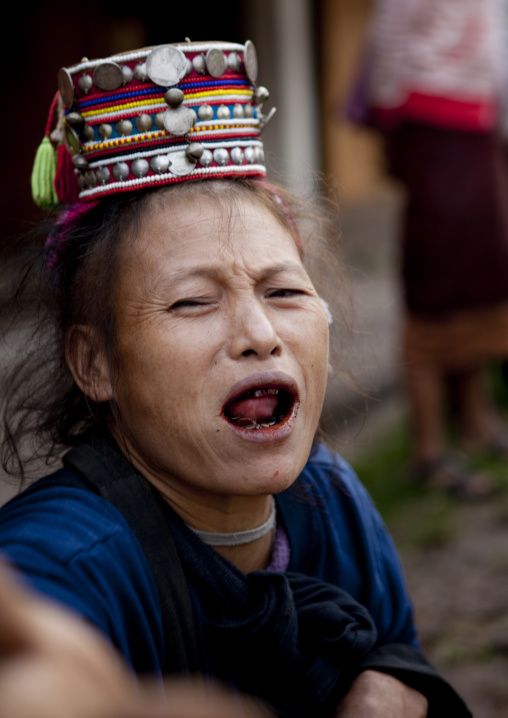 Akha minority woman with traditional headdress and black teeth, Muang sing, Laos