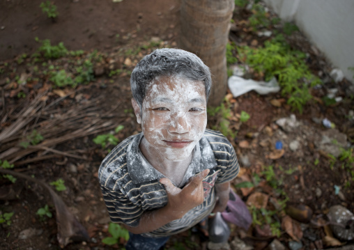 Boy with flour on the face during pii mai lao new year celebration, Luang prabang, Laos