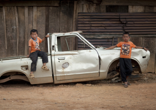Hmong minority kids sitting on an ld car, Luang prabang, Laos