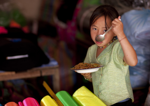 Girl eating in a shop, Phonsavan, Laos