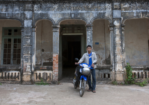 Man on his motorbike in front of an old french colonial house, Thakhek, Laos