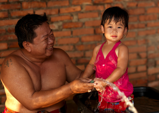Father and daughter playing with water, Vientiane, Laos
