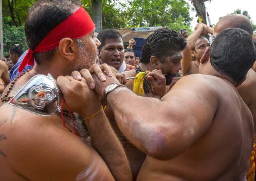 A Devotee Cheek Is Pierced With A Giant Skewer By A Priest At Thaipusam Hindu Festival At Batu Caves, Southeast Asia, Kuala Lumpur, Malaysia