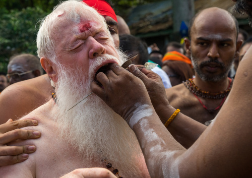 Carl, An Australian Hindu Devotee Cheek Is Pierced By A Priest At Thaipusam Hindu Festival At Batu Cave, Southeast Asia, Kuala Lumpur, Malaysia