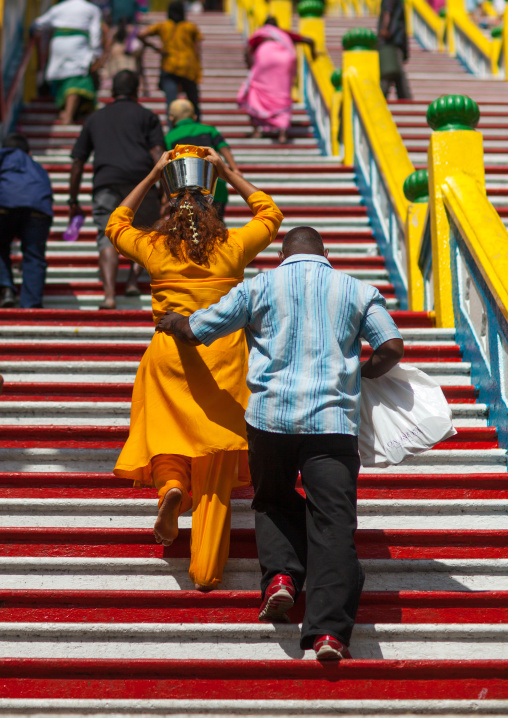 Hindu Devotee Woman Climbing Stairs With Water Jug On Her Head In Annual Thaipusam Religious Festival In Batu Caves, Southeast Asia, Kuala Lumpur, Malaysia