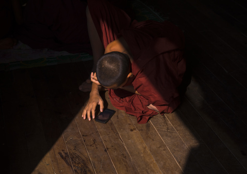 Novice Buddhist In Shwe Yan Pyay Monastery Playing With His Mobile Phone, Myanmar