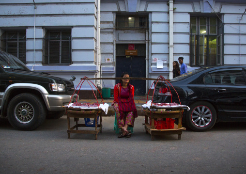 Woman Selling Food Between Two Luxury Cars In The Street,  Yangon, Myanmar