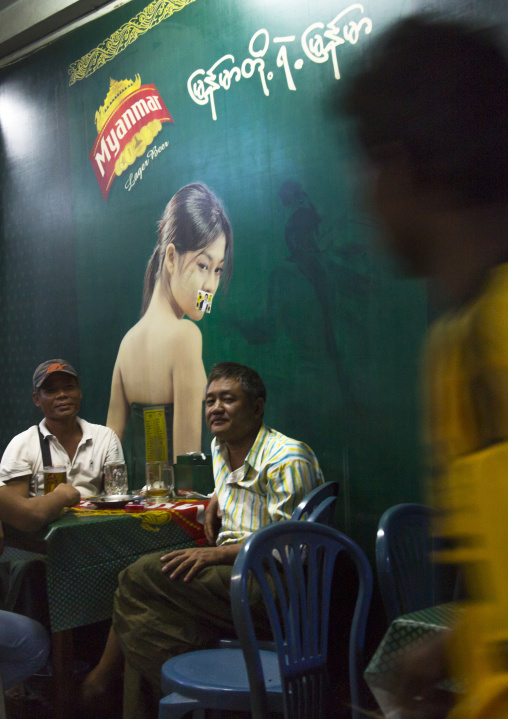 Men Inside A Bar In Front Of A Big Advertising, Yangon, Myanmar