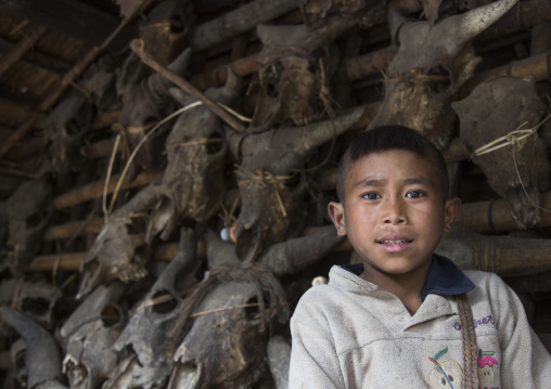 Chin Boy In Front Of Skulls At The Entrance Of His House, Mindat, Myanmar