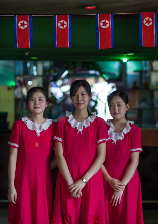 North Korean waitresses in a restaurant decorated with national flags, Pyongan Province, Pyongyang, North Korea