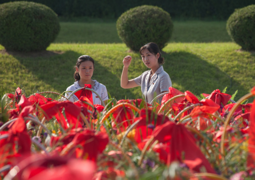 North Korean women in front of bunches of flowers in Mansudae Grand monument, Pyongan Province, Pyongyang, North Korea
