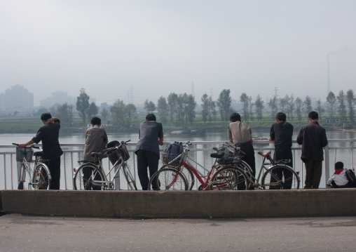 North Korean men looking over Taedong river, Pyongan Province, Pyongyang, North Korea