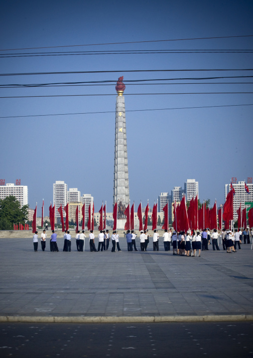 North Korean people with red flags in front of the Juche tower, Pyongan Province, Pyongyang, North Korea