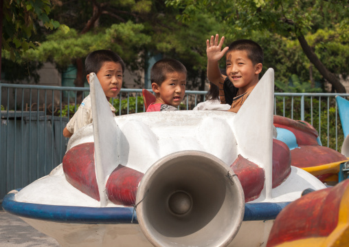 North Korean children having fun on a flying saucer attraction in Taesongsan funfair, Pyongan Province, Pyongyang, North Korea
