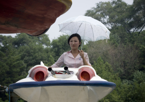 North Korean woman having fun on a flying saucer attraction in Taesongsan funfair, Pyongan Province, Pyongyang, North Korea