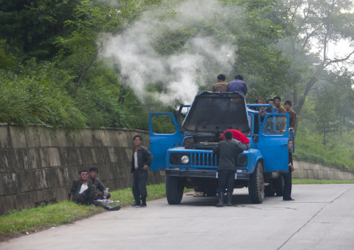 North Korean men repairing a smoking vapor truck on a highway, North Hwanghae Province, Chilbo Sea, North Korea