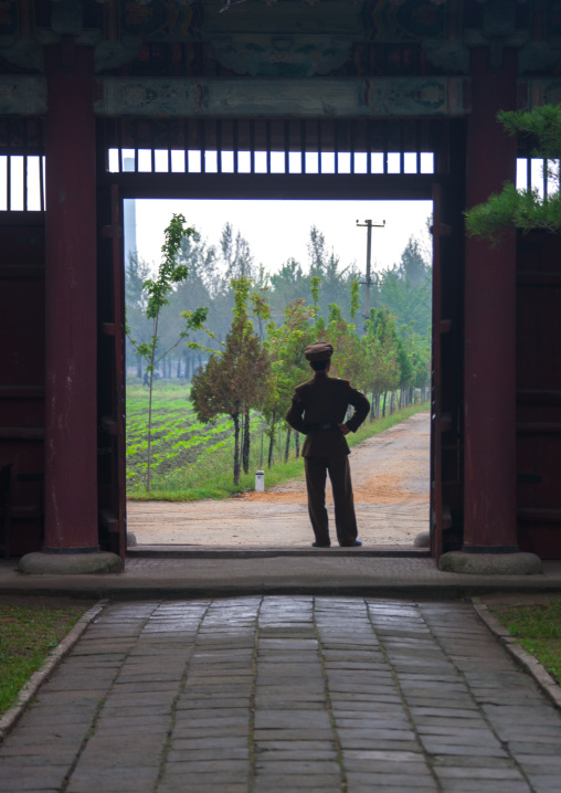 North Korean man standing at the entrance of the former royal villa of Ri Song Gye founder of the choson dynasty, South Hamgyong Province, Hamhung, North Korea