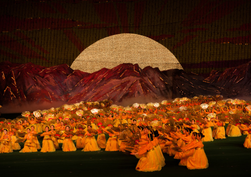 North Korean dancers in front of rising sun over mount Paektu made by children holding up boards during Arirang mass games in may day stadium, Pyongan Province, Pyongyang, North Korea