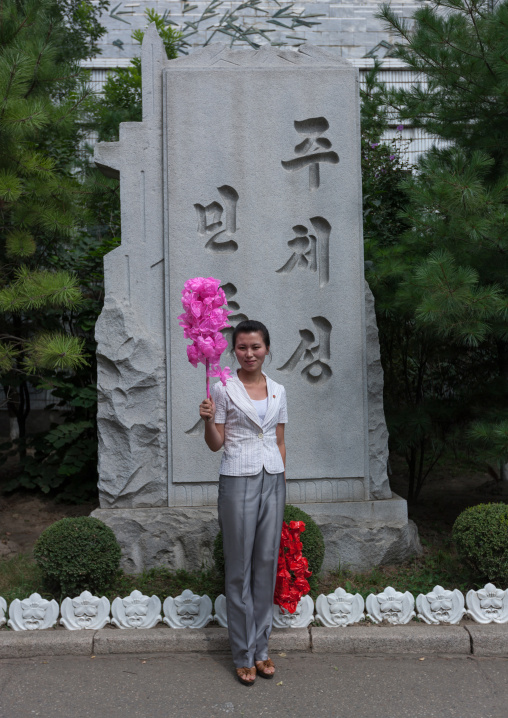 North Korean woman with plastic flowers going celebrate the day of the foundation of the republic, Pyongan Province, Pyongyang, North Korea