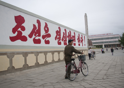 North Korean man passing in front of a propaganda billboard, North Hwanghae Province, Kaesong, North Korea