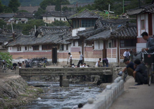North Korean people crossing bridge over a little river in the old town, North Hwanghae Province, Kaesong, North Korea