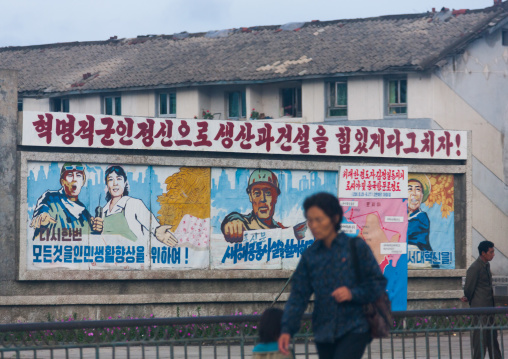 North Korean people passing in front of propaganda billboards, Kangwon-do, Kumgang, North Korea