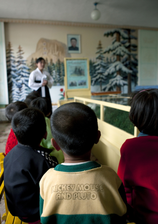 North Korean children with a Mickey shirt learning the life of Kim Jong-il, South Pyongan Province, Chongsan-ri Cooperative Farm, North Korea