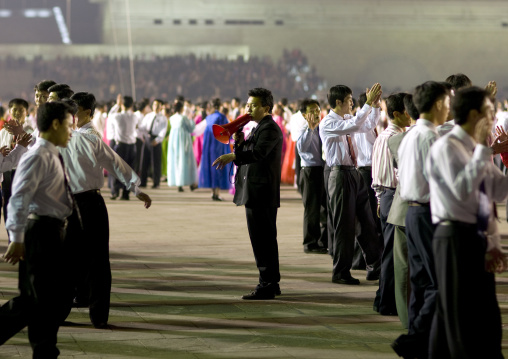 North Korean man with a megaphone giving orders to students dancing to celebrate april 15 the birth anniversary of Kim Il-sung, Pyongan Province, Pyongyang, North Korea