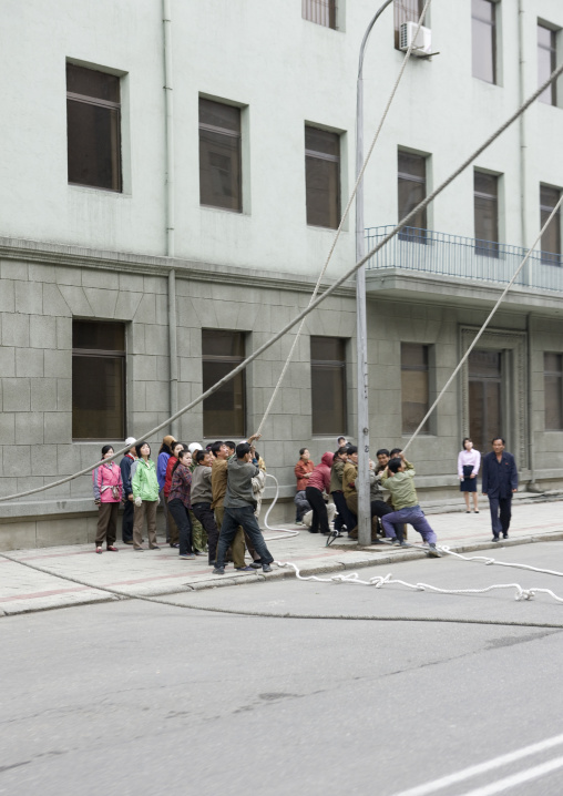 North Korean people pulling on ropes in the street, Pyongan Province, Pyongyang, North Korea