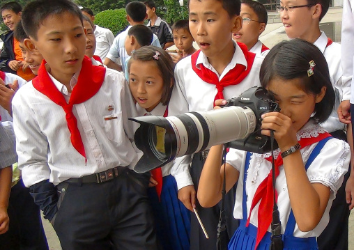 Pionner girl taking picture with a canon camera and a huge zoom, Kangwon Province, Wonsan, North Korea
