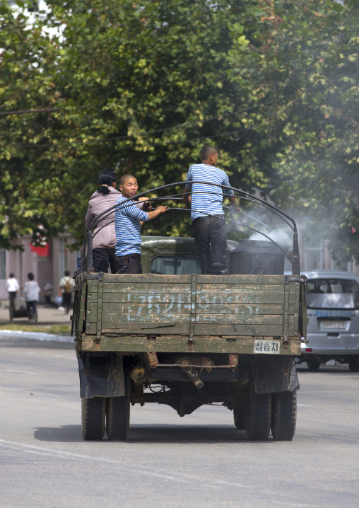 North Korean people on the back of a wood-burning steam truck in the street, South Hamgyong Province, Hamhung, North Korea