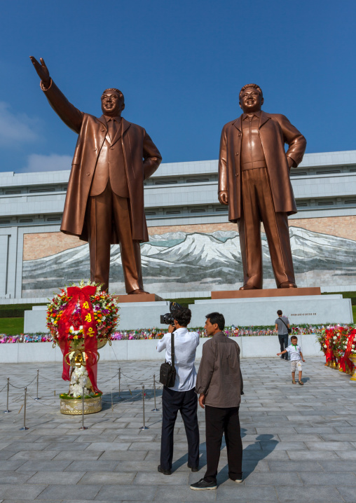 North Korean cameraman in front of the statues of the Dear Leaders in Mansudae Grand monument, Pyongan Province, Pyongyang, North Korea