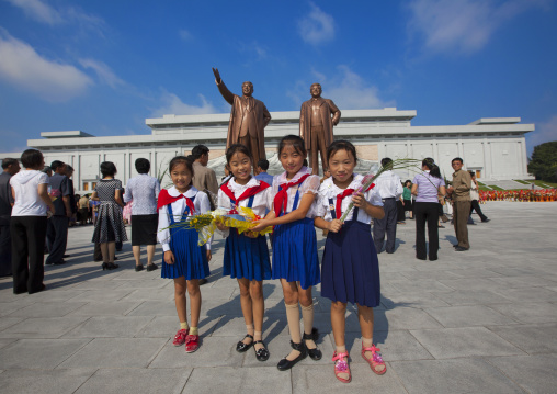 North Korean pioneers girls from the Korean children's union in front of the two statues of the Dear Leaders in the Grand monument on Mansu hill, Pyongan Province, Pyongyang, North Korea