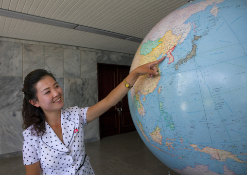 North Korean guide showing North Korea on a globe at Songdowon international children's camp, Kangwon Province, Wonsan, North Korea