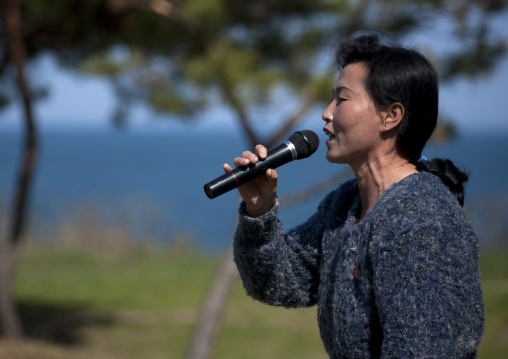 North Korean woman singing with a mircophone during a pioneers camp, North Hamgyong Province, Chilbo Sea, North Korea