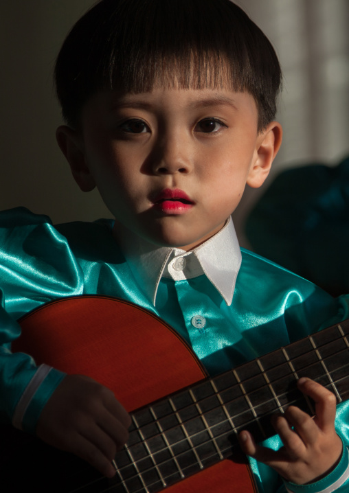 North Korean boy playing guitar in Tchang Gwang school, North Hamgyong Province, Chongjin, North Korea