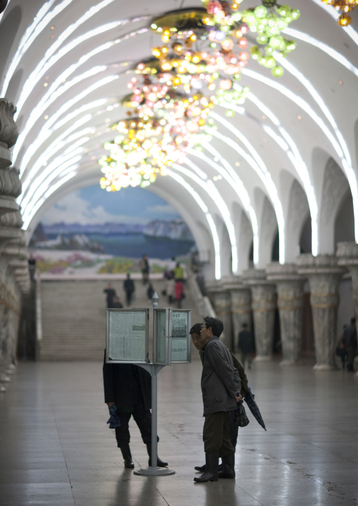 North Korean people reading the offical state newspaper in a subway station, Pyongan Province, Pyongyang, North Korea