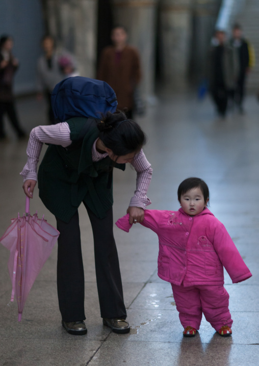 North Korean toddler in pink clothes in the subway with her mother, Pyongan Province, Pyongyang, North Korea