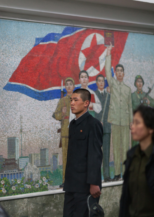 North Korean people in the subway in front of a propaganda mosaic, Pyongan Province, Pyongyang, North Korea