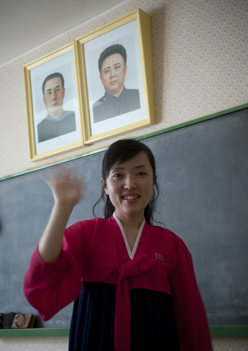 North Korean teacher under the offcial portraits of the Dear Leaders in Kwangbok school, Pyongan Province, Pyongyang, North Korea