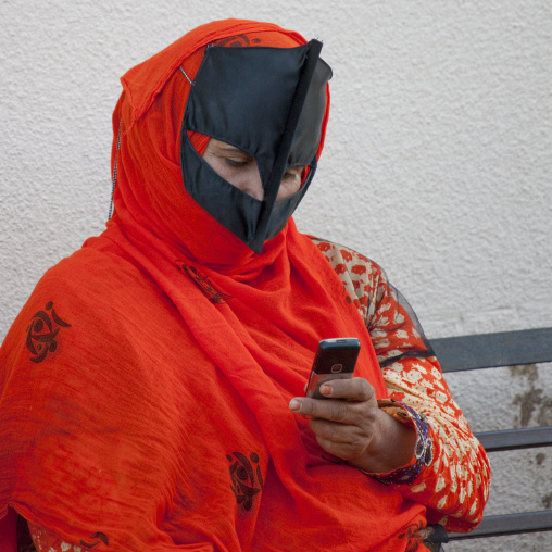Bedouin Woman Looking At Mobile Phone, Sinaw, Oman