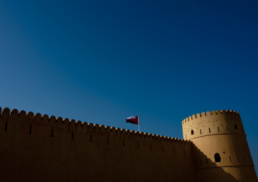 Wall Of The Sineslah Fort With Flying Flag, Sur, Oman