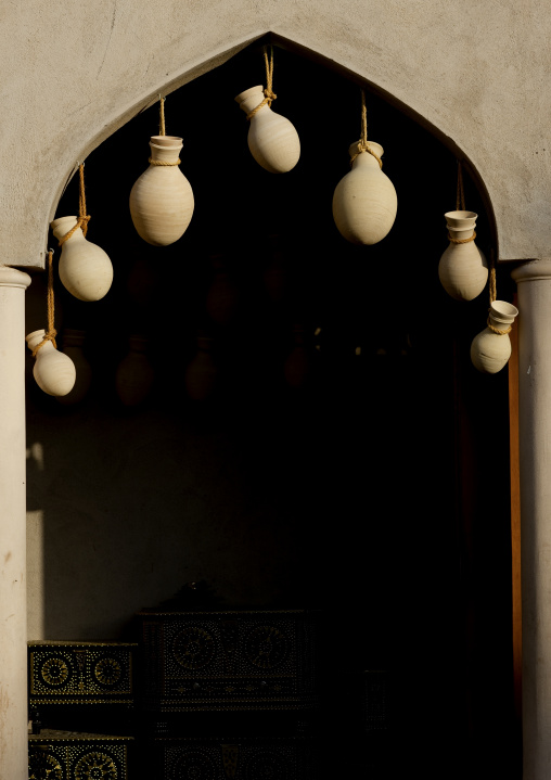 Hand Made Pots Hung Up On The Door And The Shining Trunks Inside The Door, Nizwa, Oman