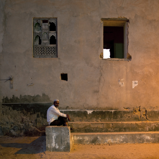 Man Sitting On Stairs Of An Old Building, Salalah, Oman