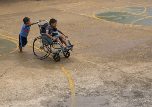 Panama, Darien Province, Bajo Chiquito, Embera Tribe Kids Playing With A Wheelchair