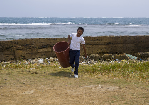 Panama, San Blas Islands, Mamitupu, Kuna Boy Collecting Garbage In A School
